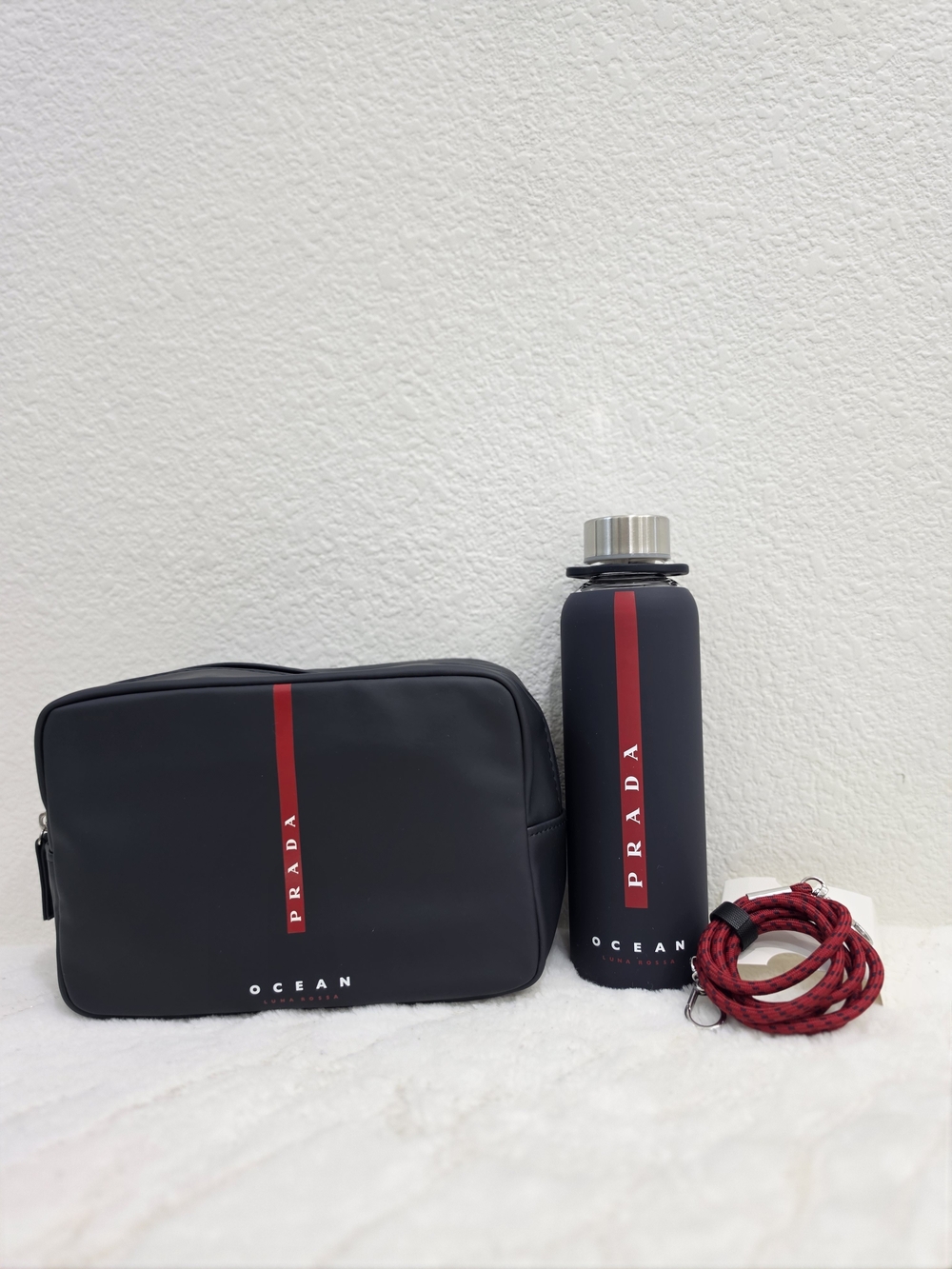 Prada Navy Toiletry Pouch and Matching glass water bottle with sleeve.